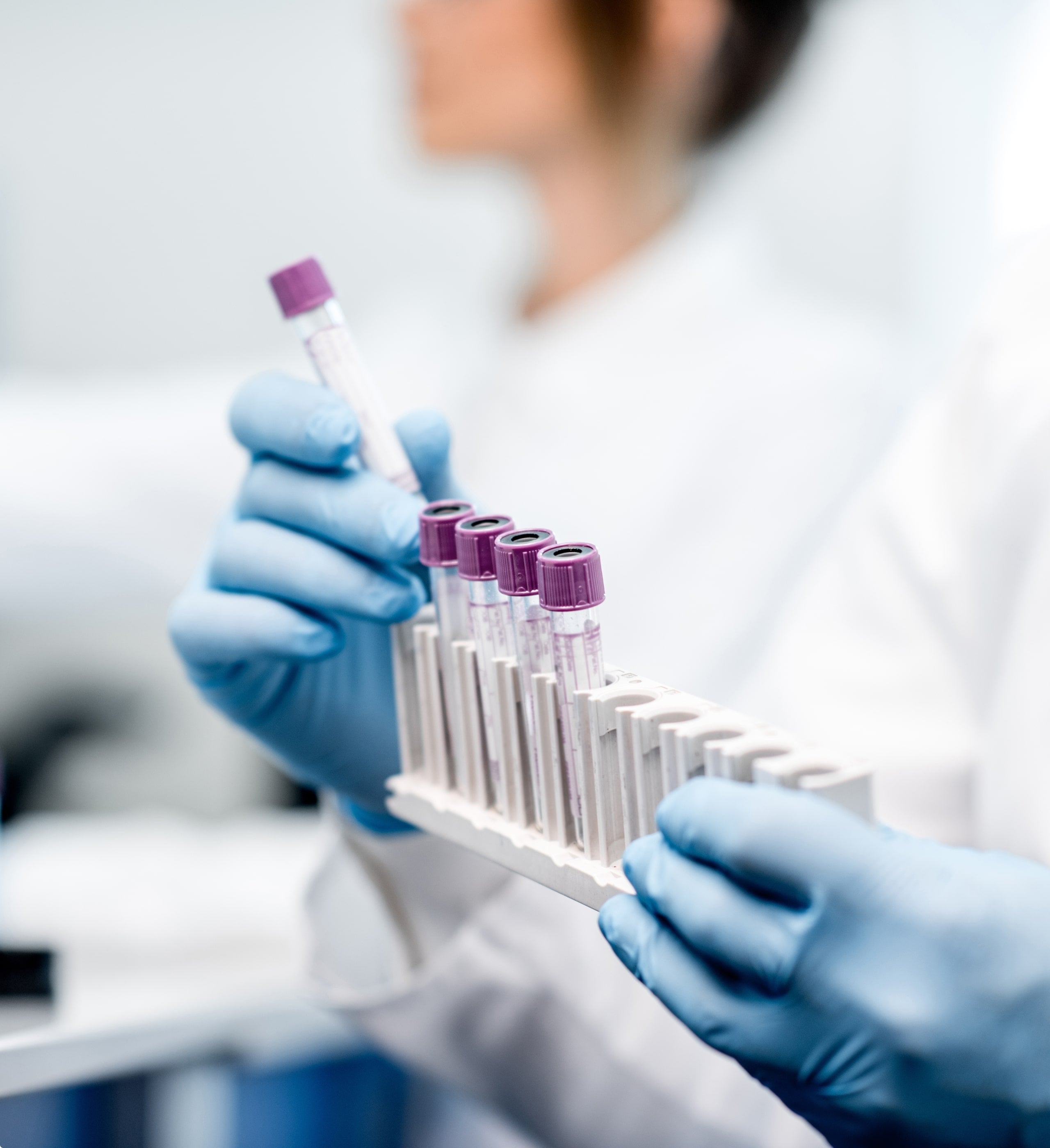 2018 milestone: Fund I momentum and expansion, gloved hands holding blood sample test tubes