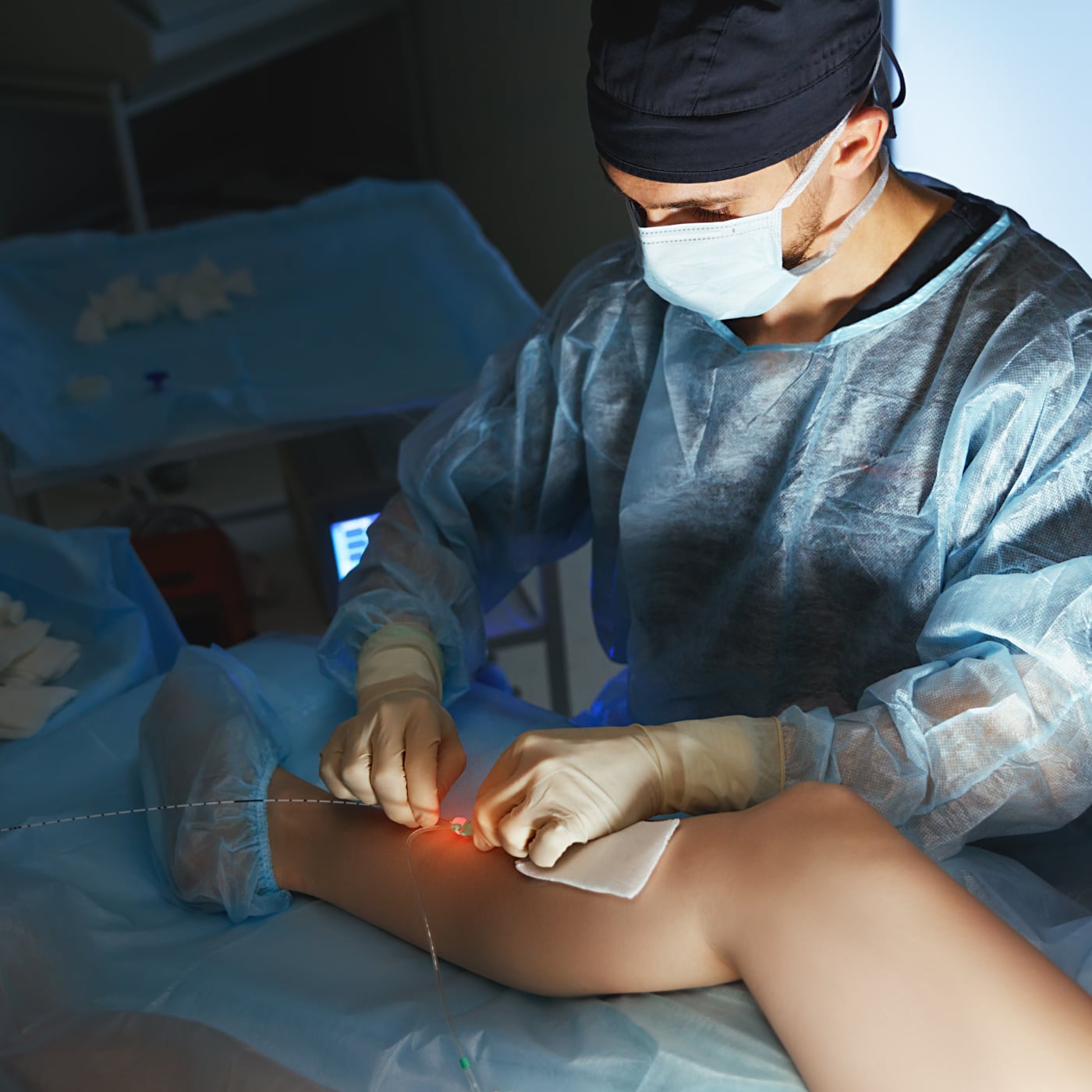 Medical professional performing a vascular procedure on a patient’s leg