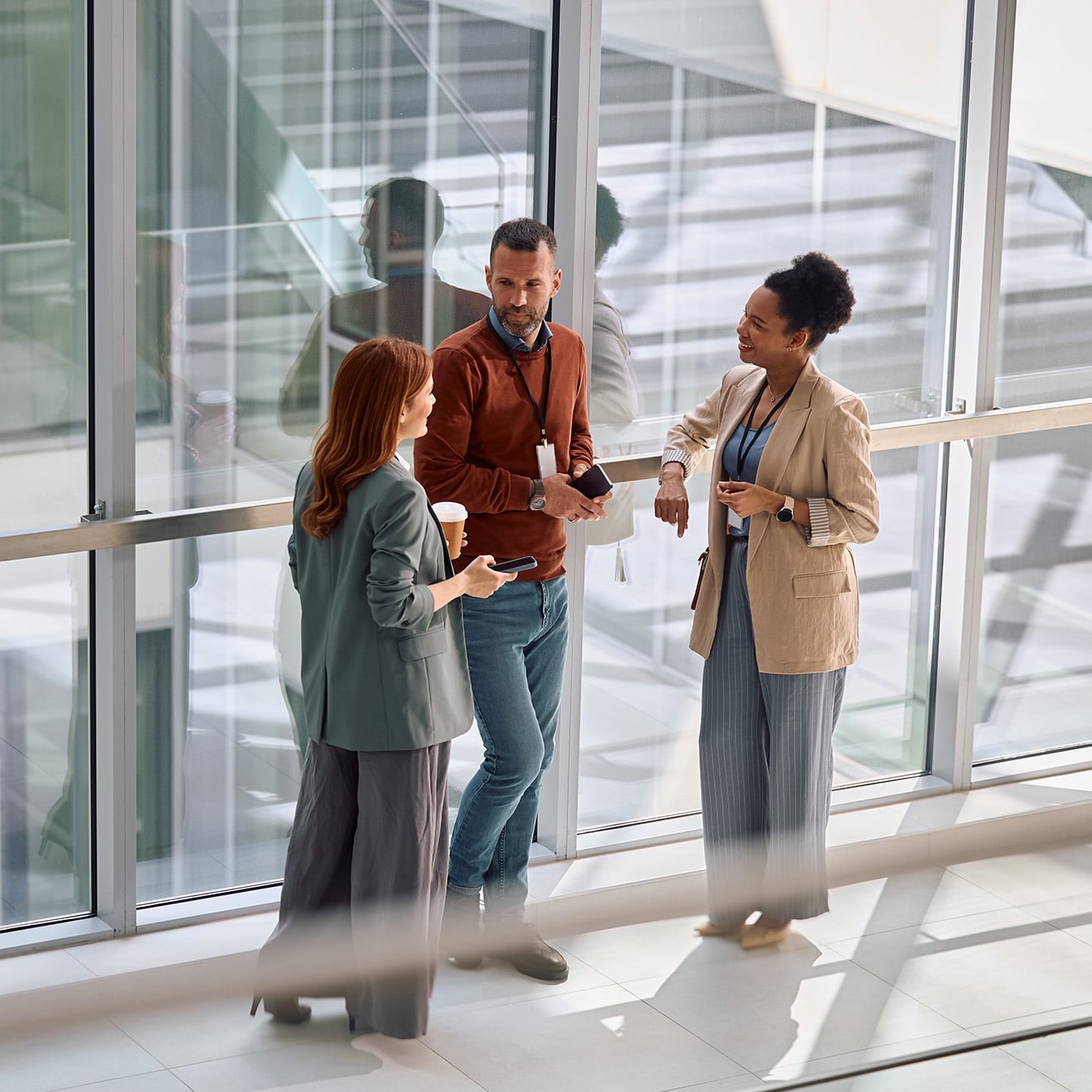 Colleagues discussing work in office hallway